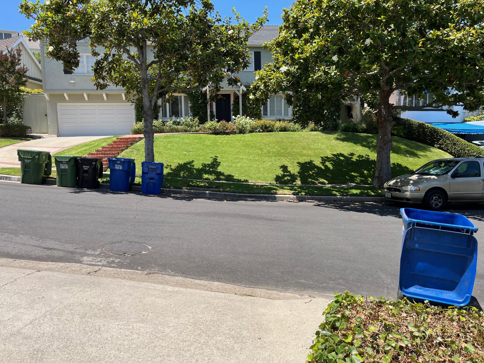 A sloping grass lawn in front of a traditional home in Cheviot Hills.