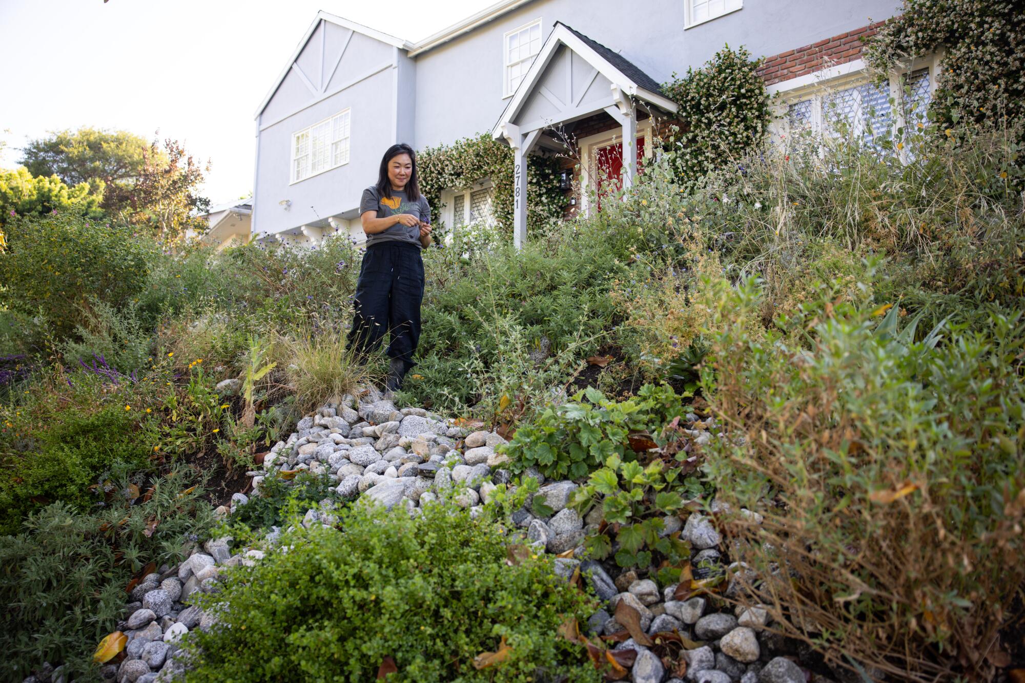 Julia Lee stands in her garden at her home in Cheviot Hills.