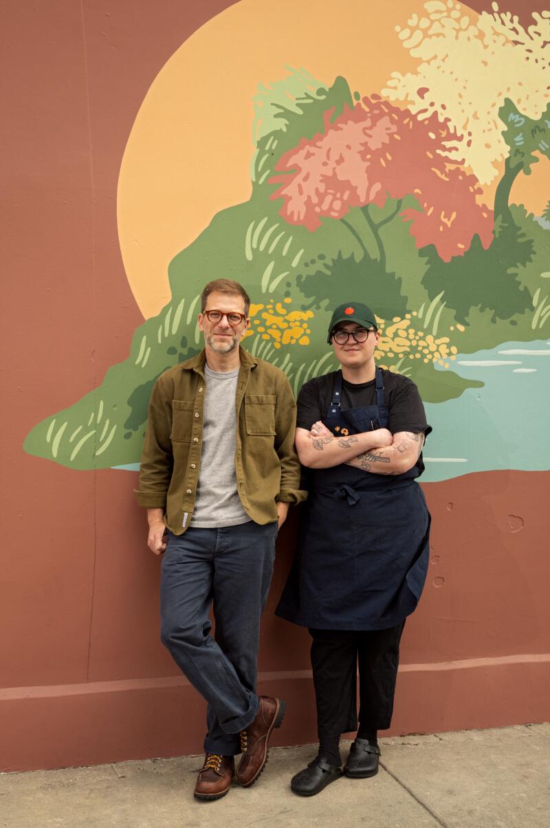 Owner Max Lesser and chef Alexis Brown in front of the wall mural at Henrietta.