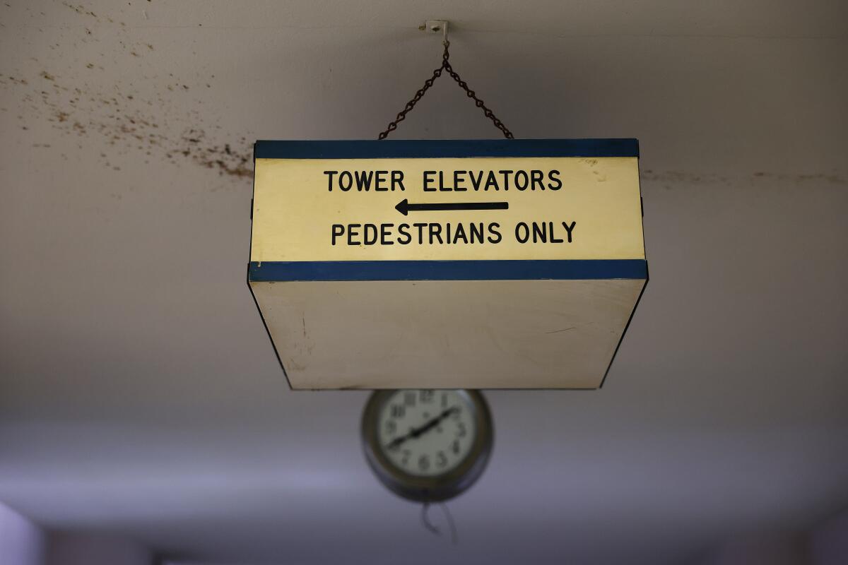  sign hands from the ceiling that says "Tower elevators pedestrians only" and an arrow pointing to the left