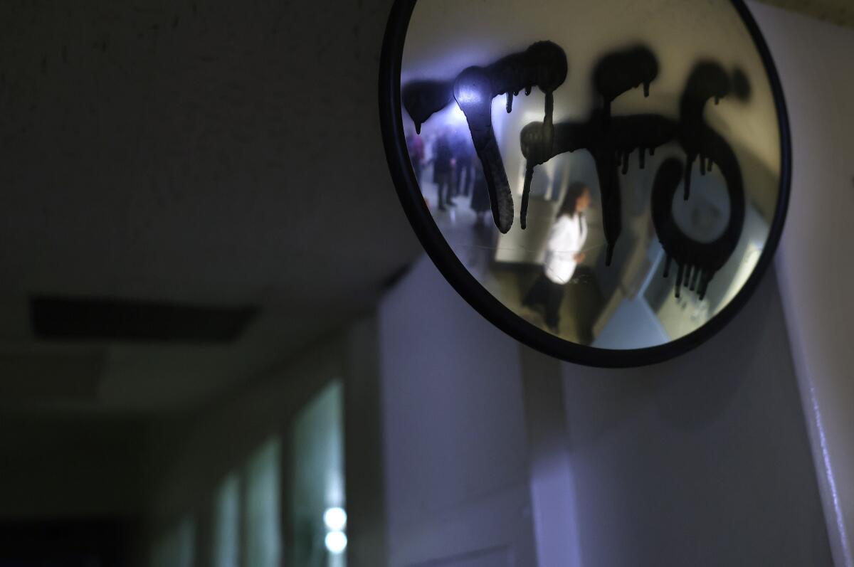 Graffiti covers a mirror inside the inpatient unit for individuals who are incarcerated