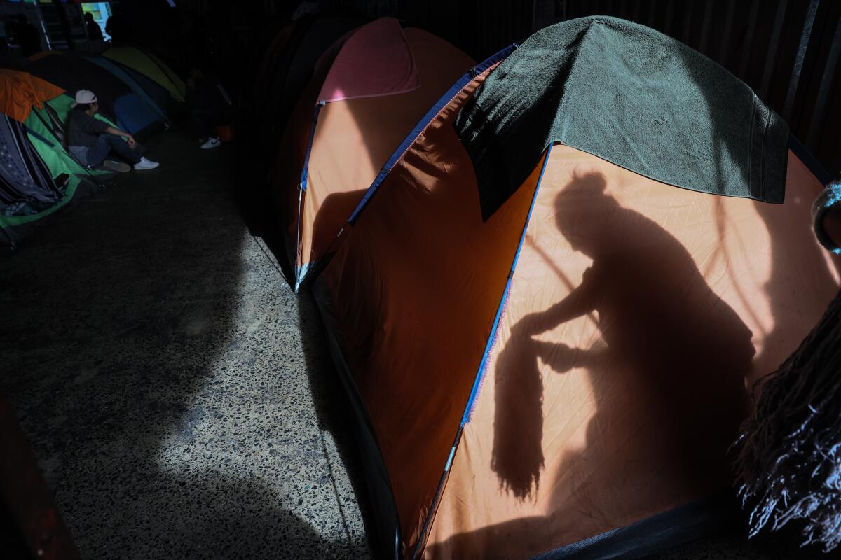 Asylum seekers rest at a Tijuana migrant shelter a day after President Trump began his second term in the White House.