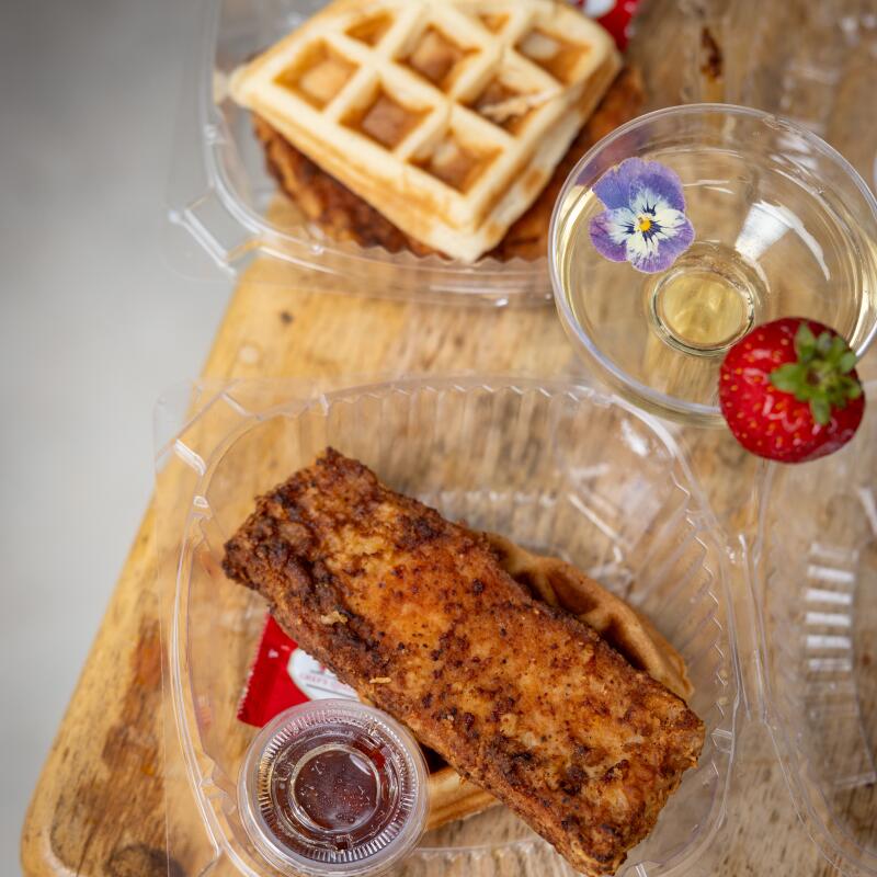 A glass of welcome champagne and a turkey chop and waffle from Breakfast with Milli, a diner in Baldwin Hills.
