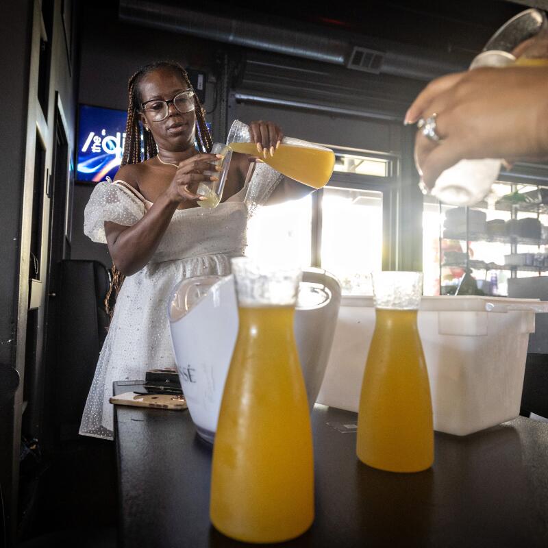 In between bus stops, host Daisy Miles preps mimosas for guests.