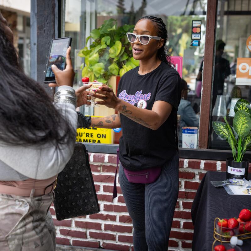 The first stop on Daisy's Black L.A. Food Tour, Breakfast with Milli owner Milli Jay serves champagne garnished with strawberries along with turkey chops and waffles.