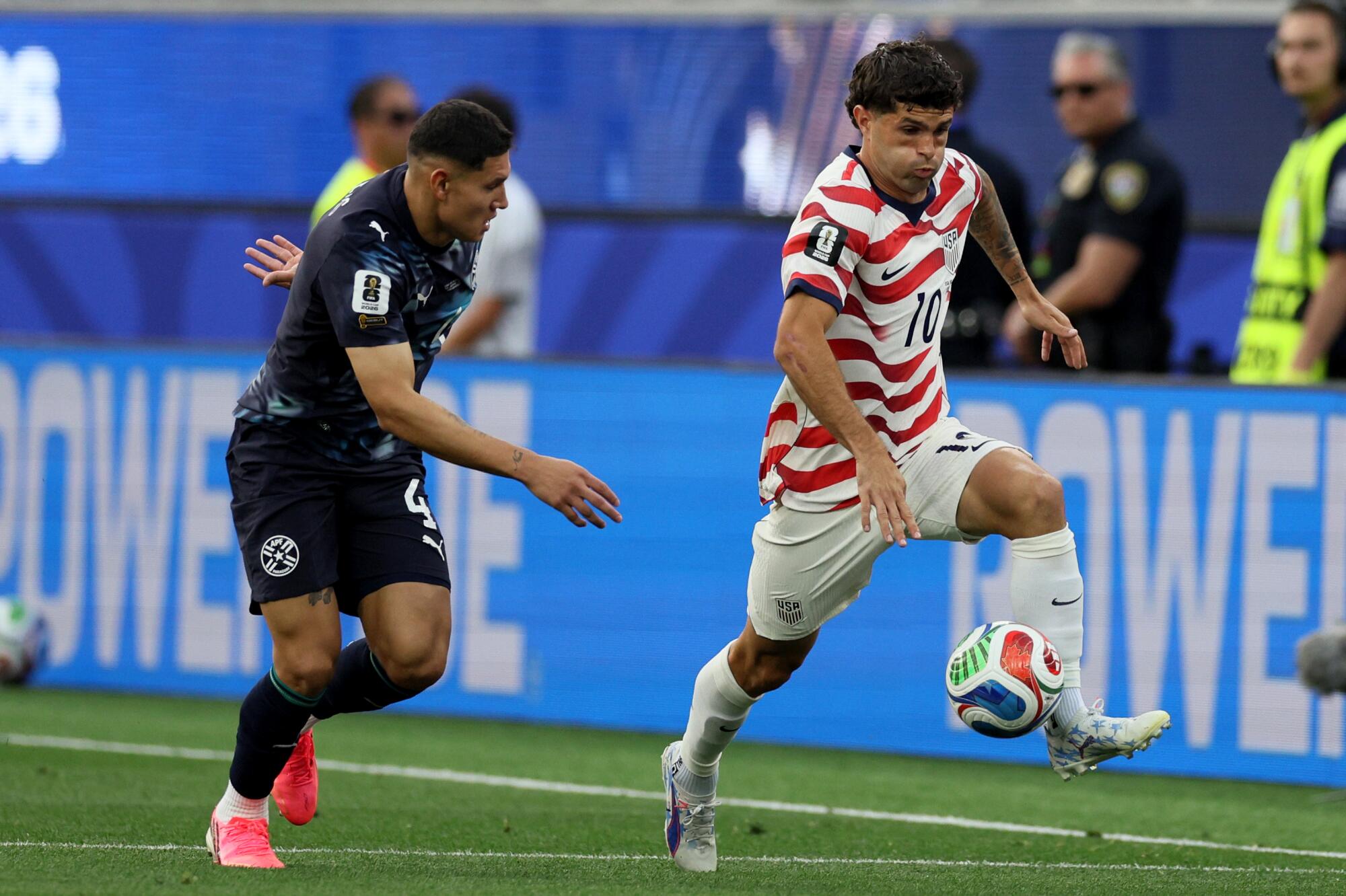 United States of America forward Christian Pulisic runs with the ball against Paraguay defender Juan Jose Caceres.