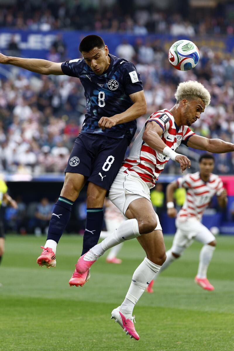 U.S. defender Antonee Robinson, right, and Paraguay midfielder Diego Gomez battle for the ball.