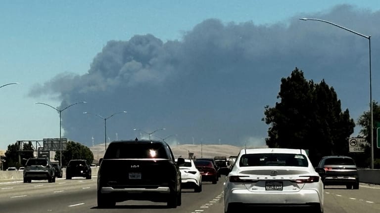 Smoke from a medical supply warehouse fire in Tracy, Calif.,...