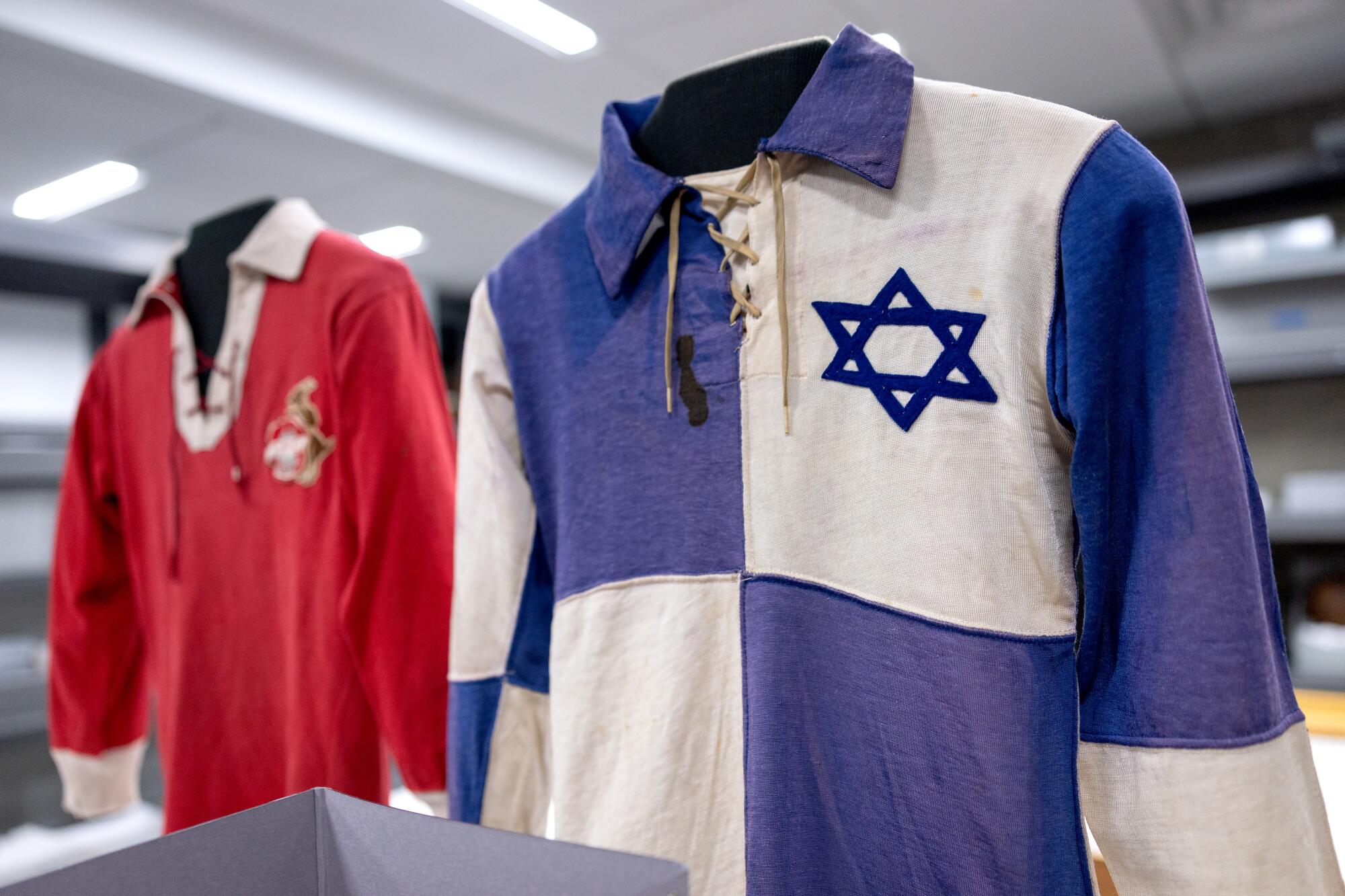 A jersey worn by player Max Wozniak and a jersey from the 1930s are displayed in an exhibit.