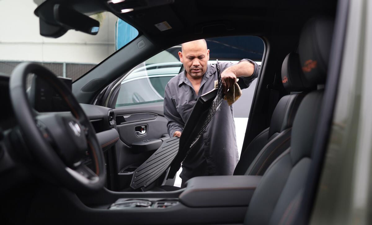 A worker cleans the interior of a car at Westchester Hand Wash.