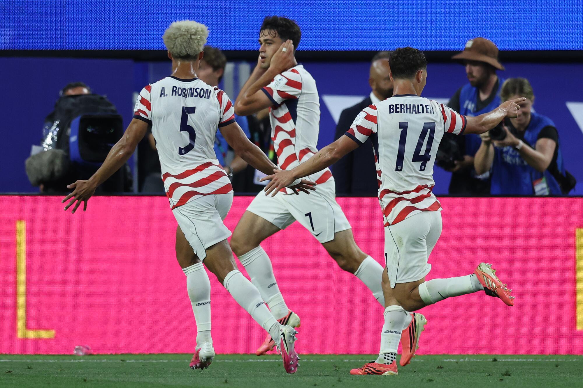 U.S. midfielder Giovanni celebrates with Antonee Robinson and Sebastian Berhalter after scoring during a World Cup game.
