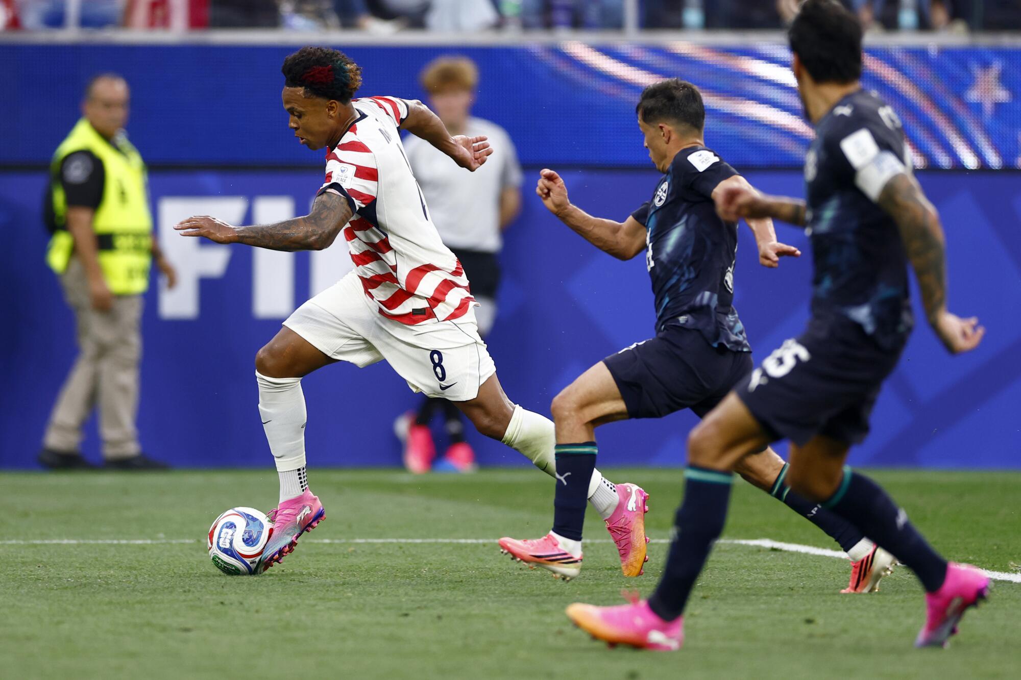 American midfielder Weston McKennie out runs two Paraguay defenders during a World Cup match at SoFi Stadium Friday. 