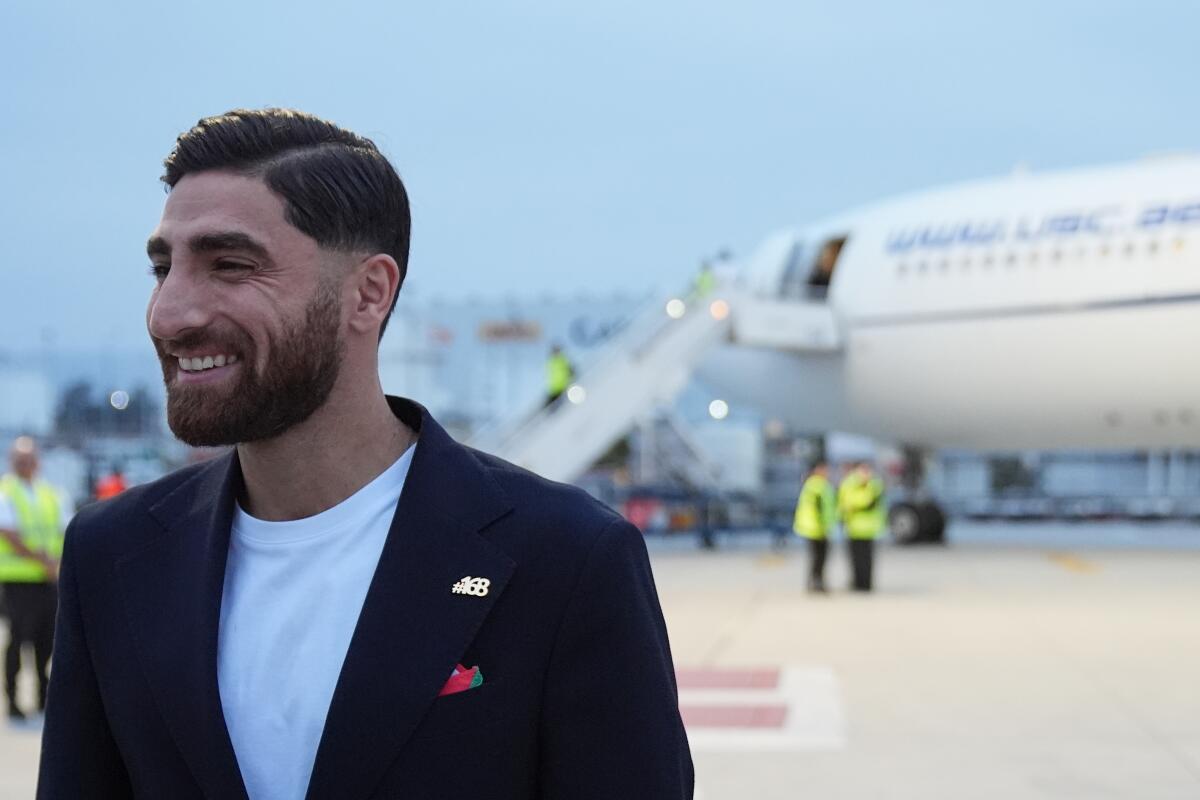 Iran's Alireza Jahanbakhsh smiles as he arrives with his teammates.