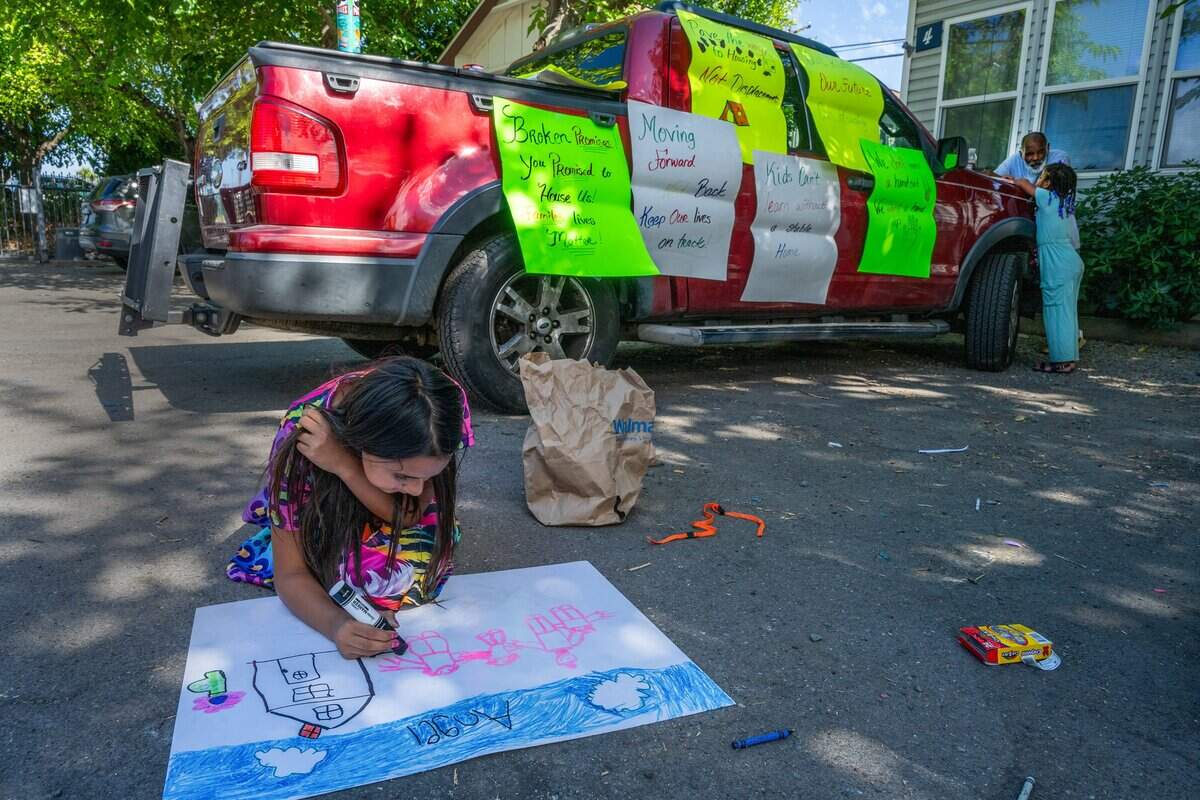 Angel Guevara, 9, begins drawing her dog, Bean, into a family picture before a news conference where four families are fighting to remain in their cottages at Arden Acres in Sacramento on Friday, June 5. A recent change to the city of Sacramento’s motel shelter program left Angel, her mother and three siblings without a place to live.