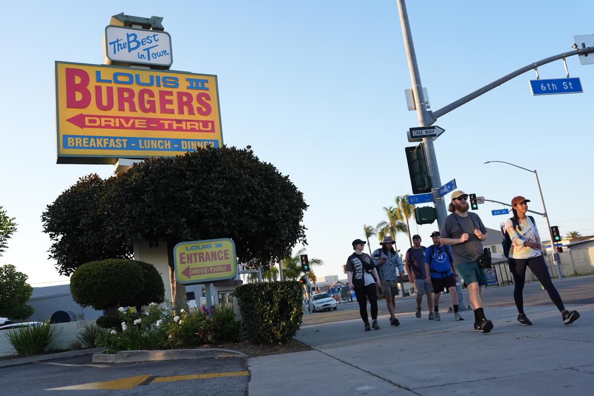 A group of walkers lead the way past Louis Burgers III on Atlantic Avenue.