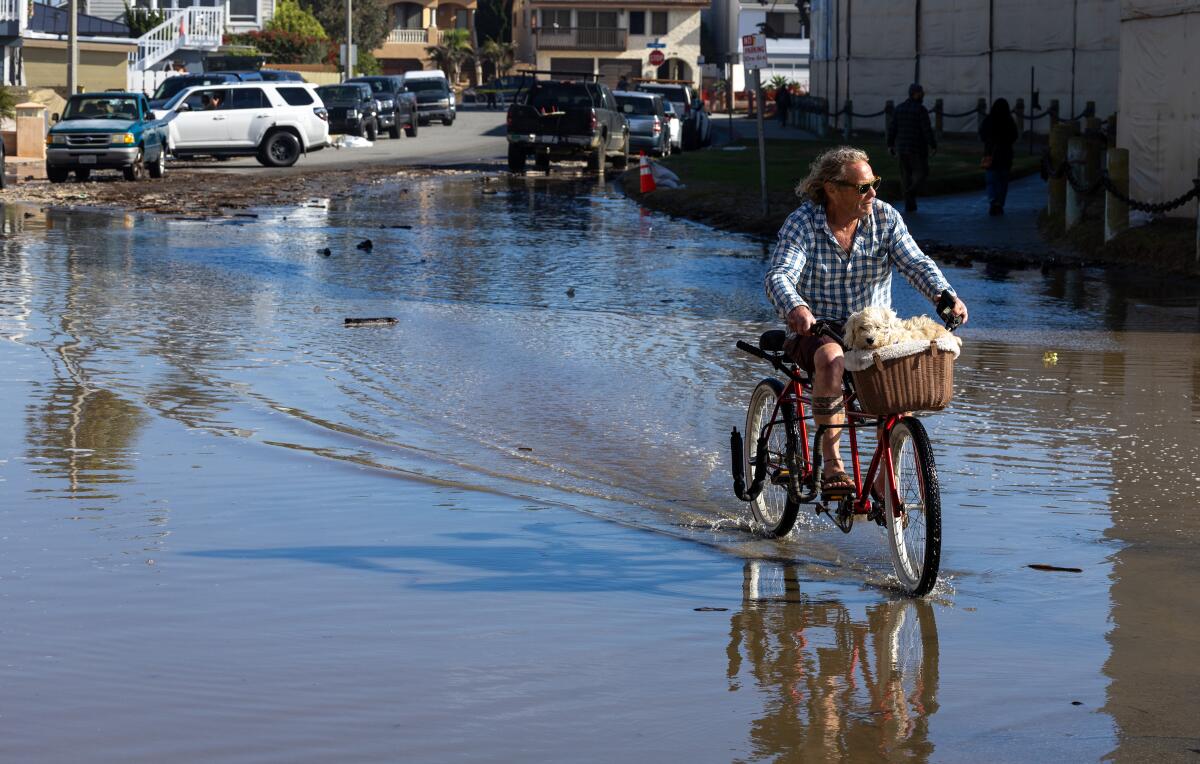 Man on bike crossing flooded road 