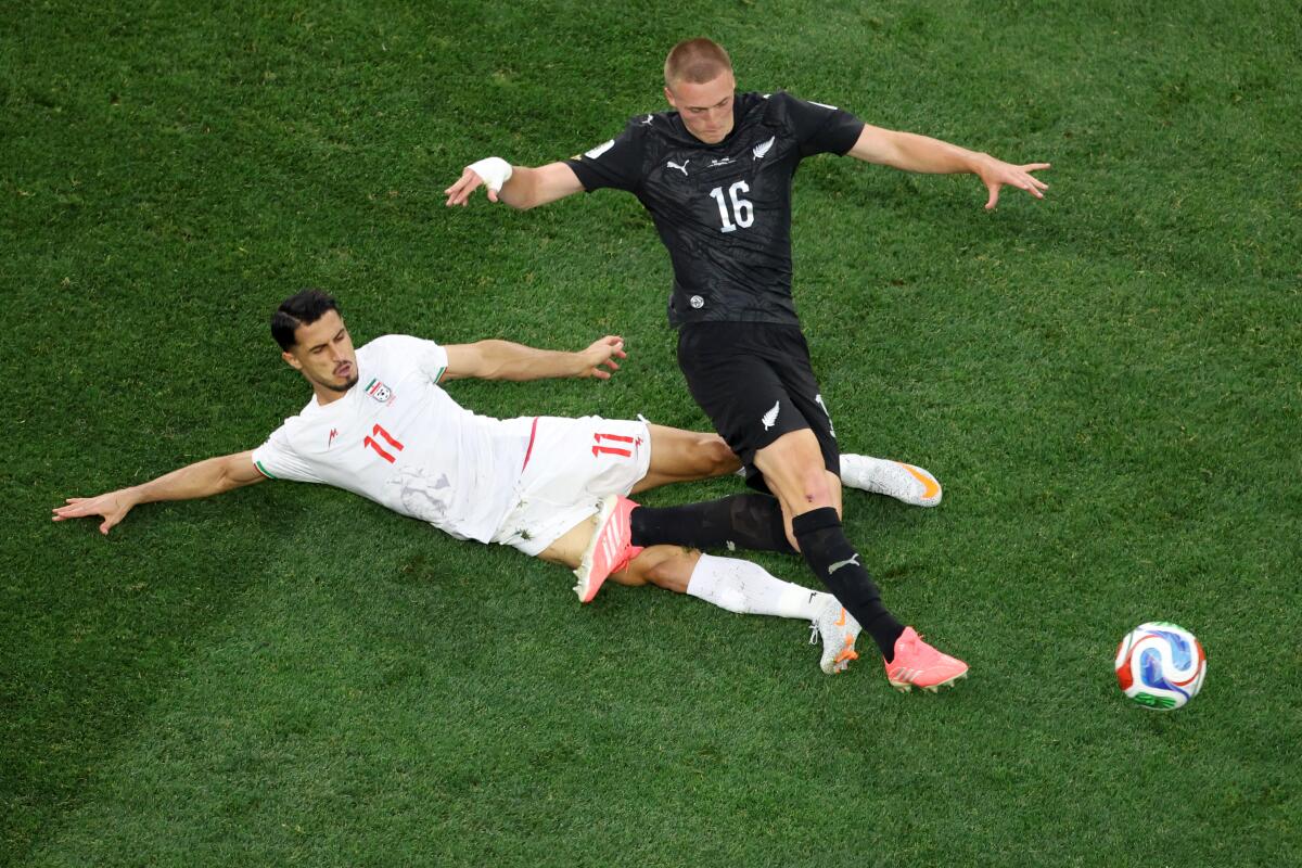New Zealand defender Finn Surman, top, goes after the ball in front of Iran forward Ali Alipour.
