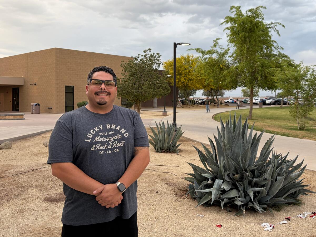 A man stands in front of a building.
