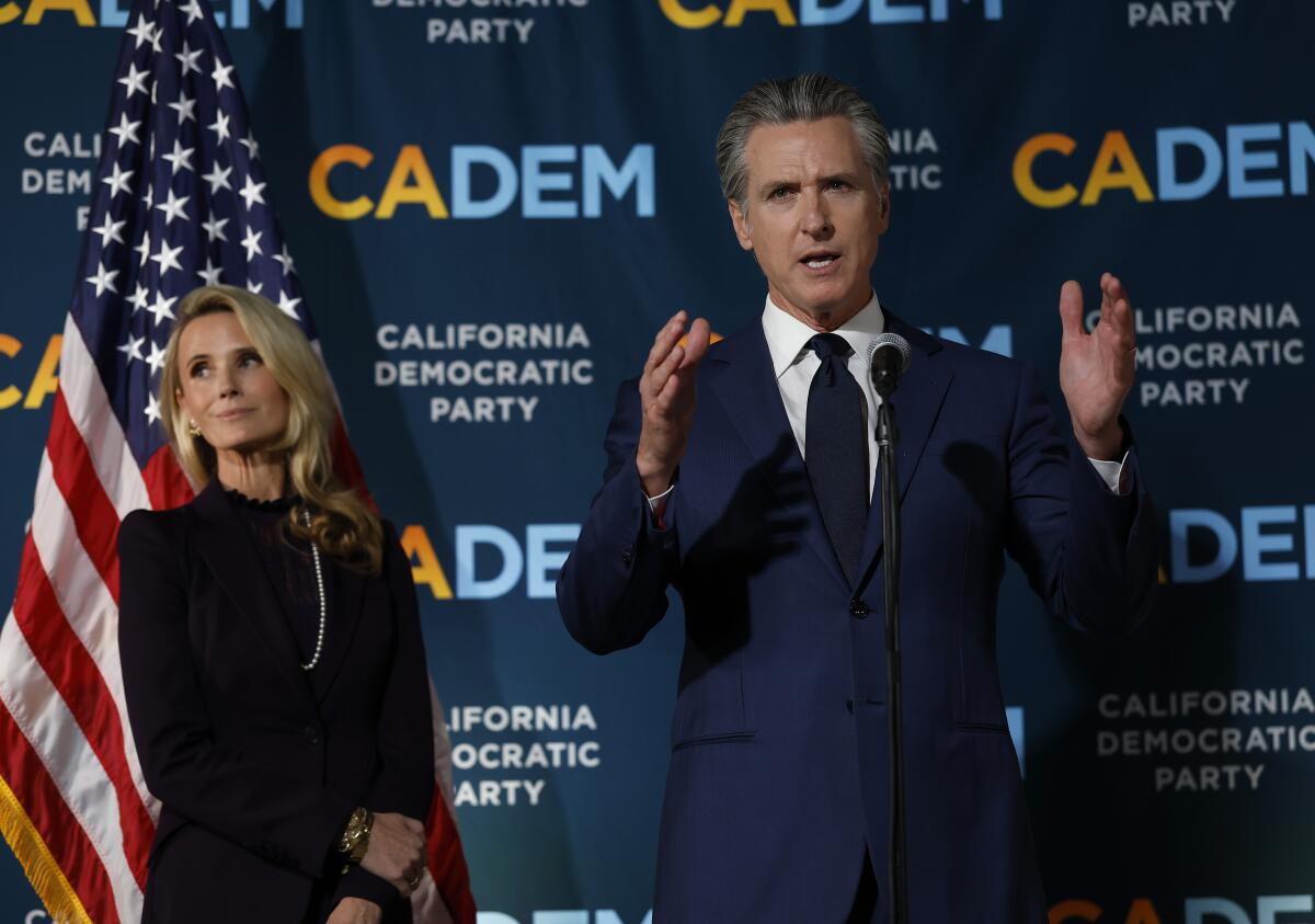 Newsom speaks as his wife Jennifer Siebel Newsom looks on during an election night gathering in 2025. 