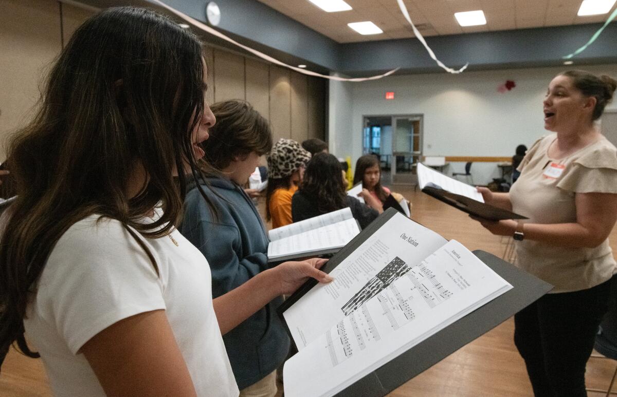 Newport Harbor High sophomore Alyssa Niles, left, joins other youth taking part in the Voices in Unity rehearsal.