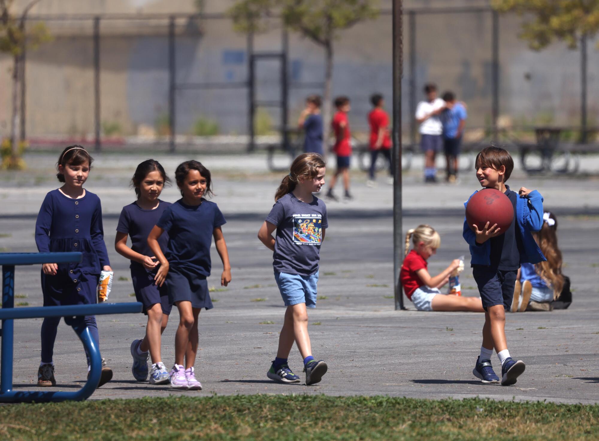 First and second graders enjoy a break on the playground during mid-morning recess