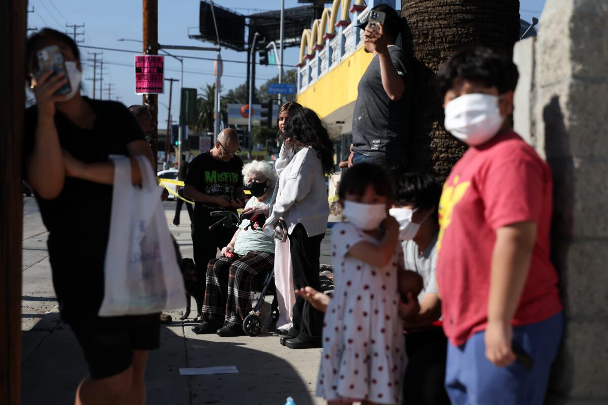 Community members watch as fire and emergency crews battle a warehouse fire.