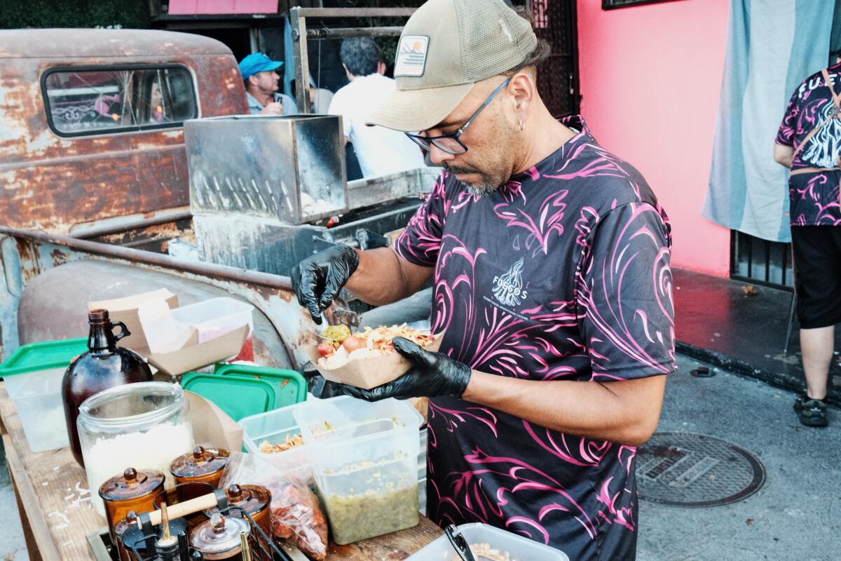Fuegos LA staff grill and prepare choripan on the patio