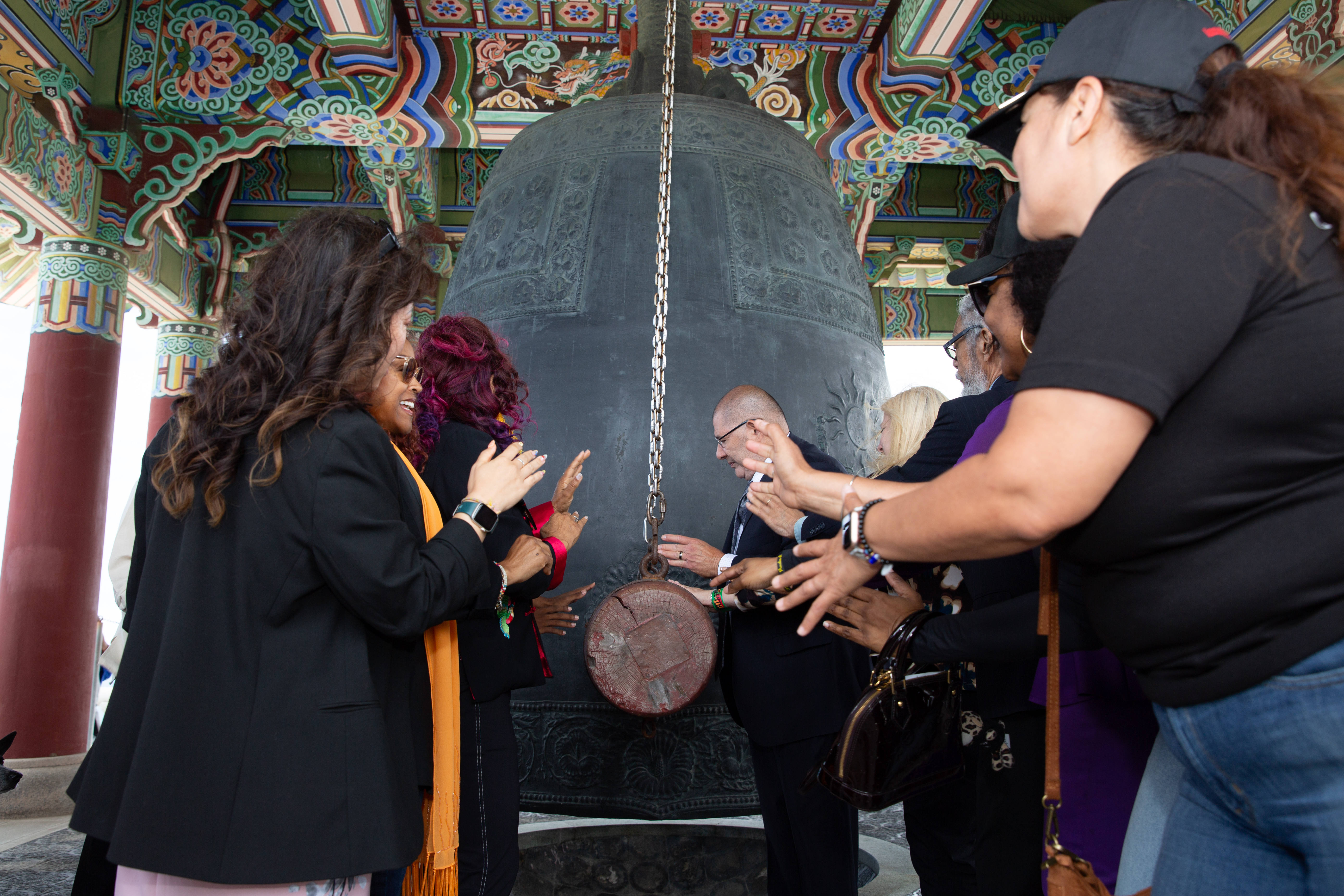 Officials and guests ring the bell during a Juneteenth celebration...