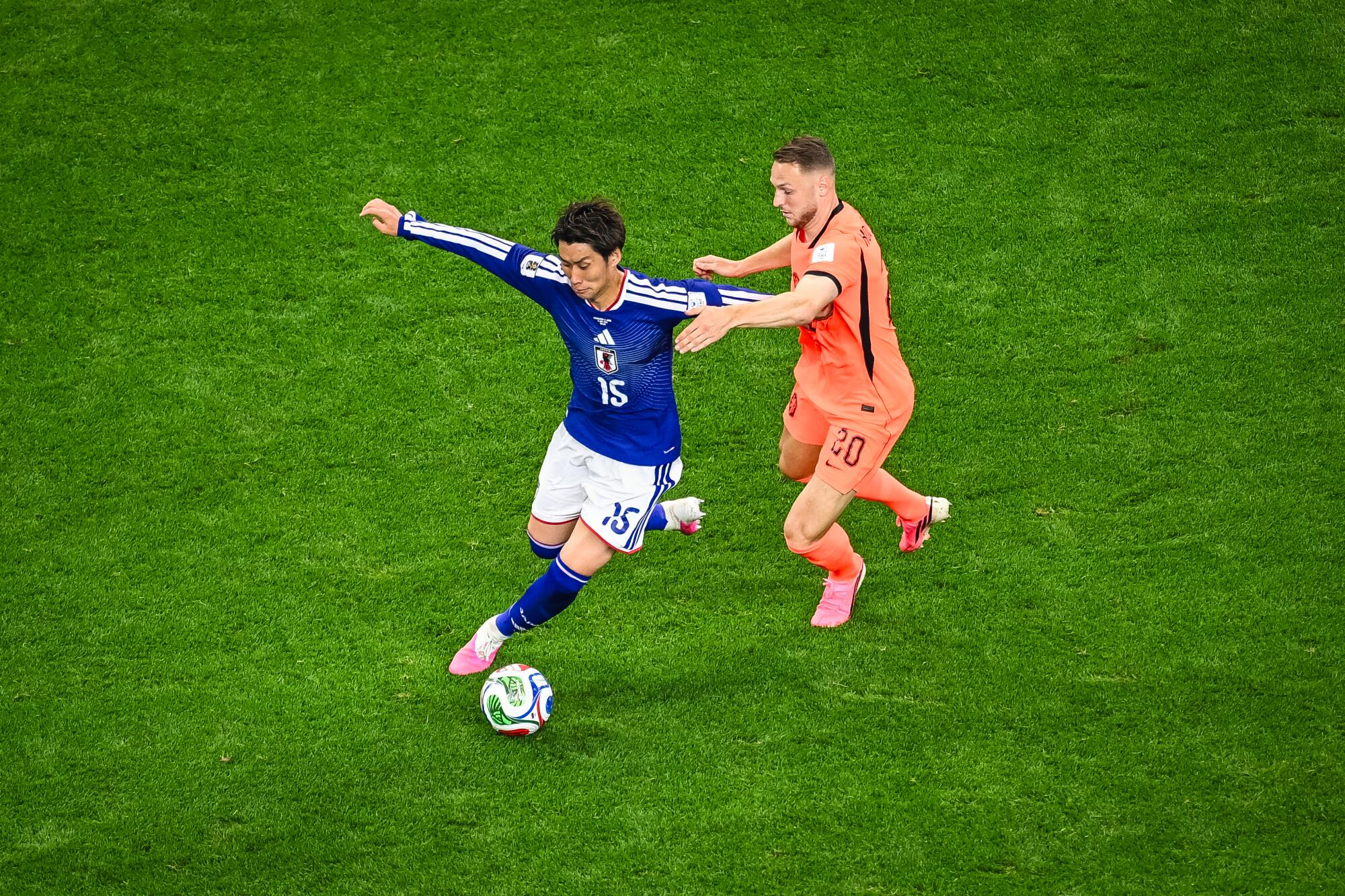 Japan's Daichi Kamada controls the ball in front of the Netherlands' Teun Koopmeiners during a World Cup match.