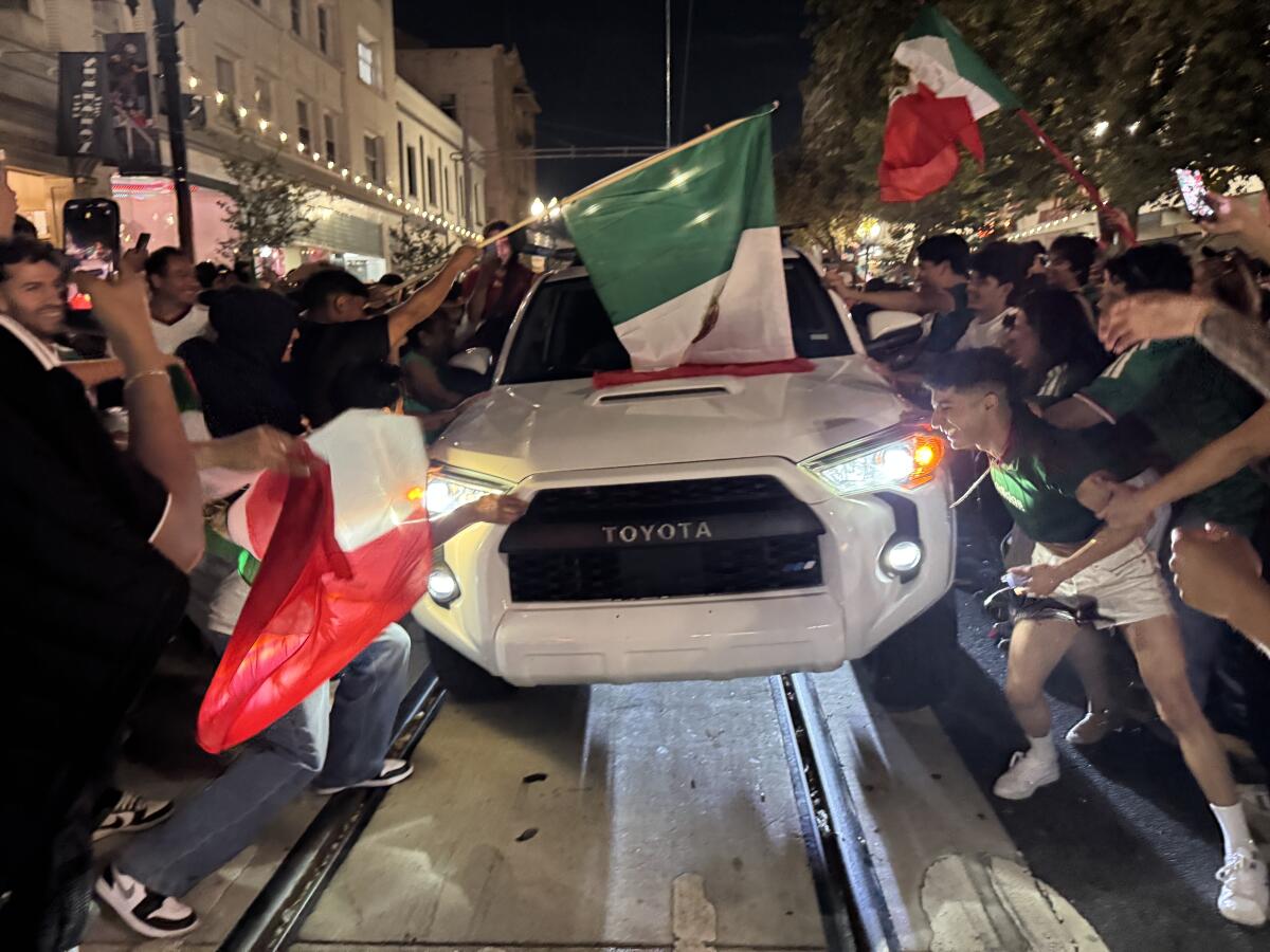 Mexico soccer fans shake a car.
