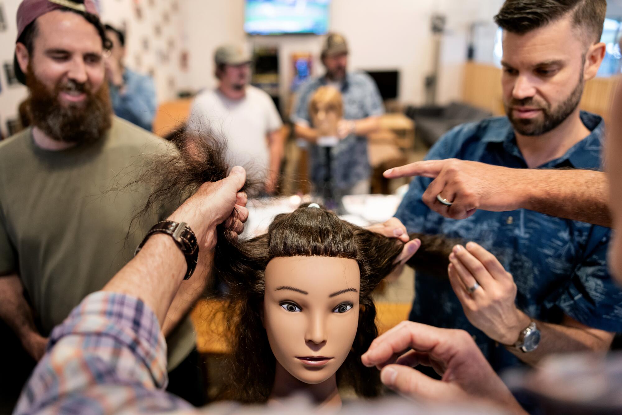 Dads learn how to style their daughters' hair on a mannequin.