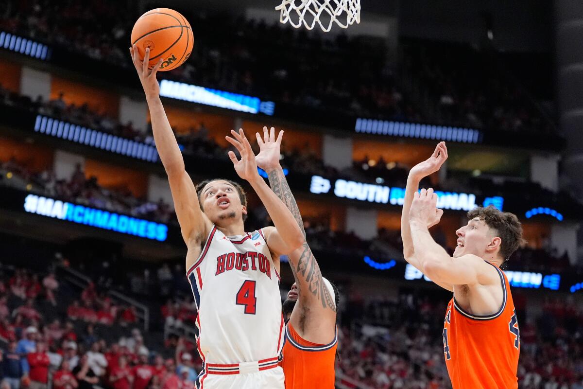 Houston guard Kingston Flemings, left, elevates for a layup past Illinois' Kylan Boswell, center, and Zvonimir Ivisic.