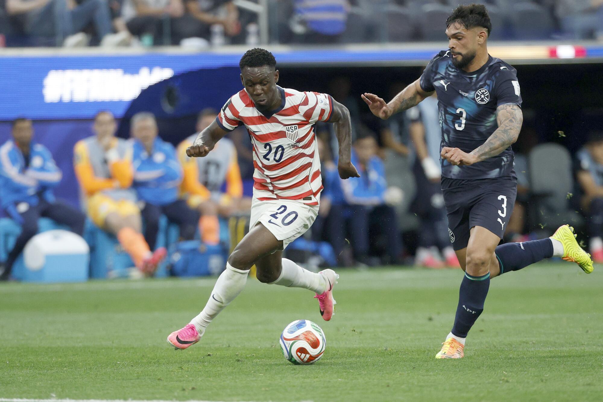 U.S. forward Folarin Balogun, left, goes after the ball against Paraguay defender Omar Alderete during a World Cup match.