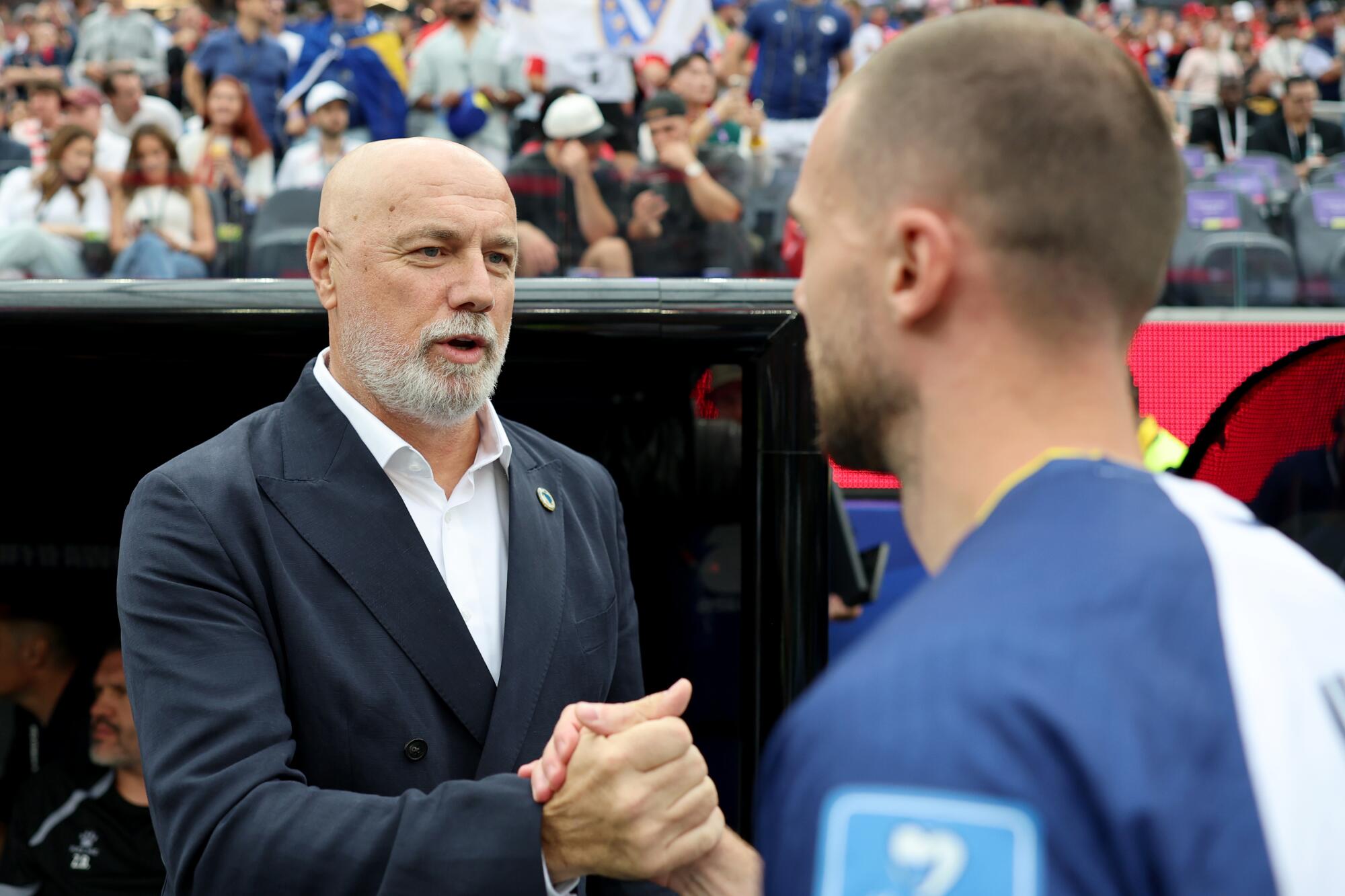 Bosnia and Herzegovina coach Sergej Barbarez shakes hands with one of his players before a loss to Switzerland.