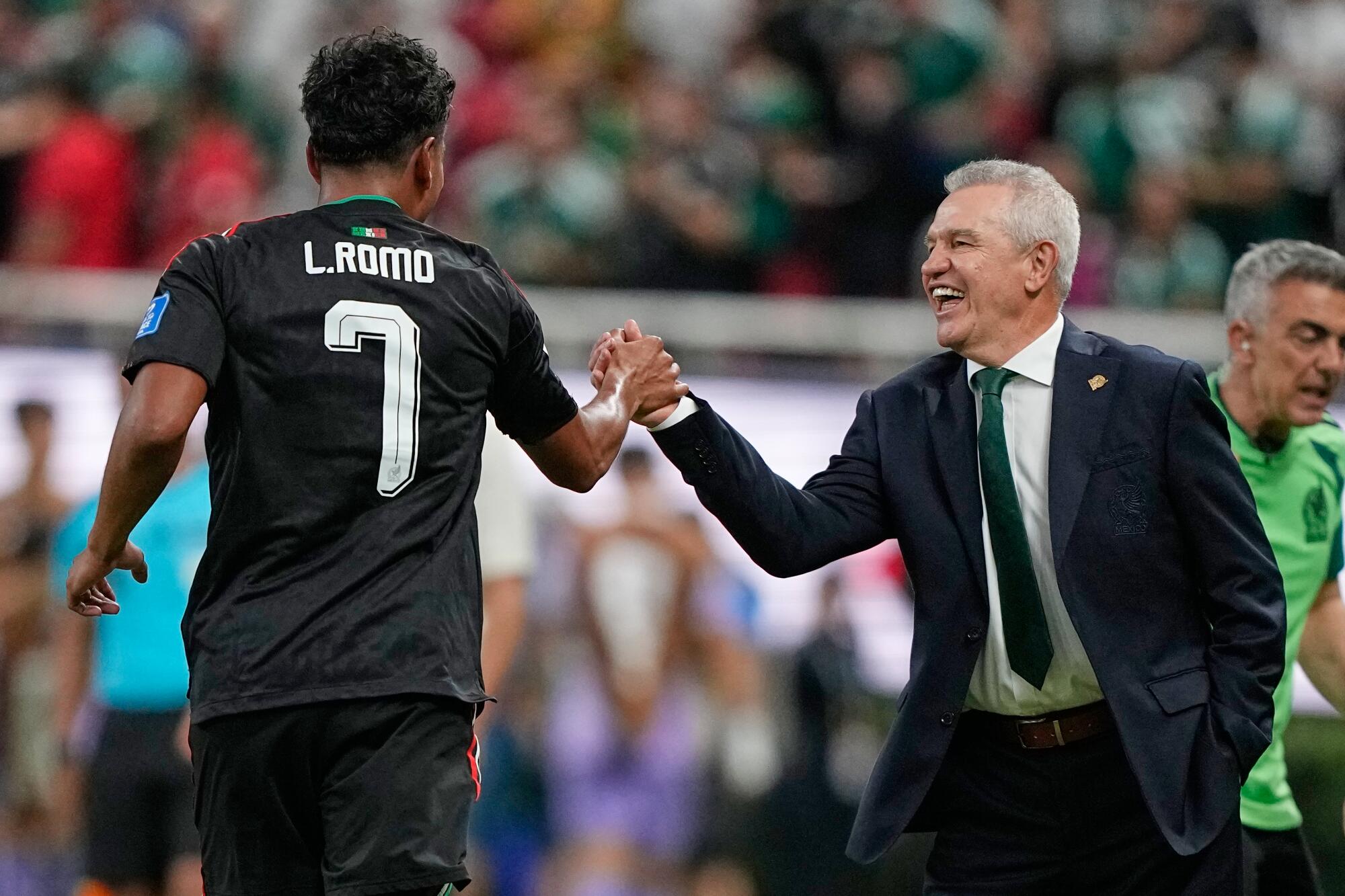 Mexico coach Javier Aguirre congratulates Luis Romo after Romo scored El Tri's goal against South Korea.