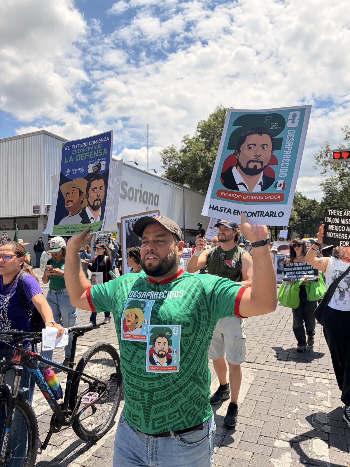 Protesters hold up signs featuring images of missing environmental activists ahead of Mexico's World Cup.