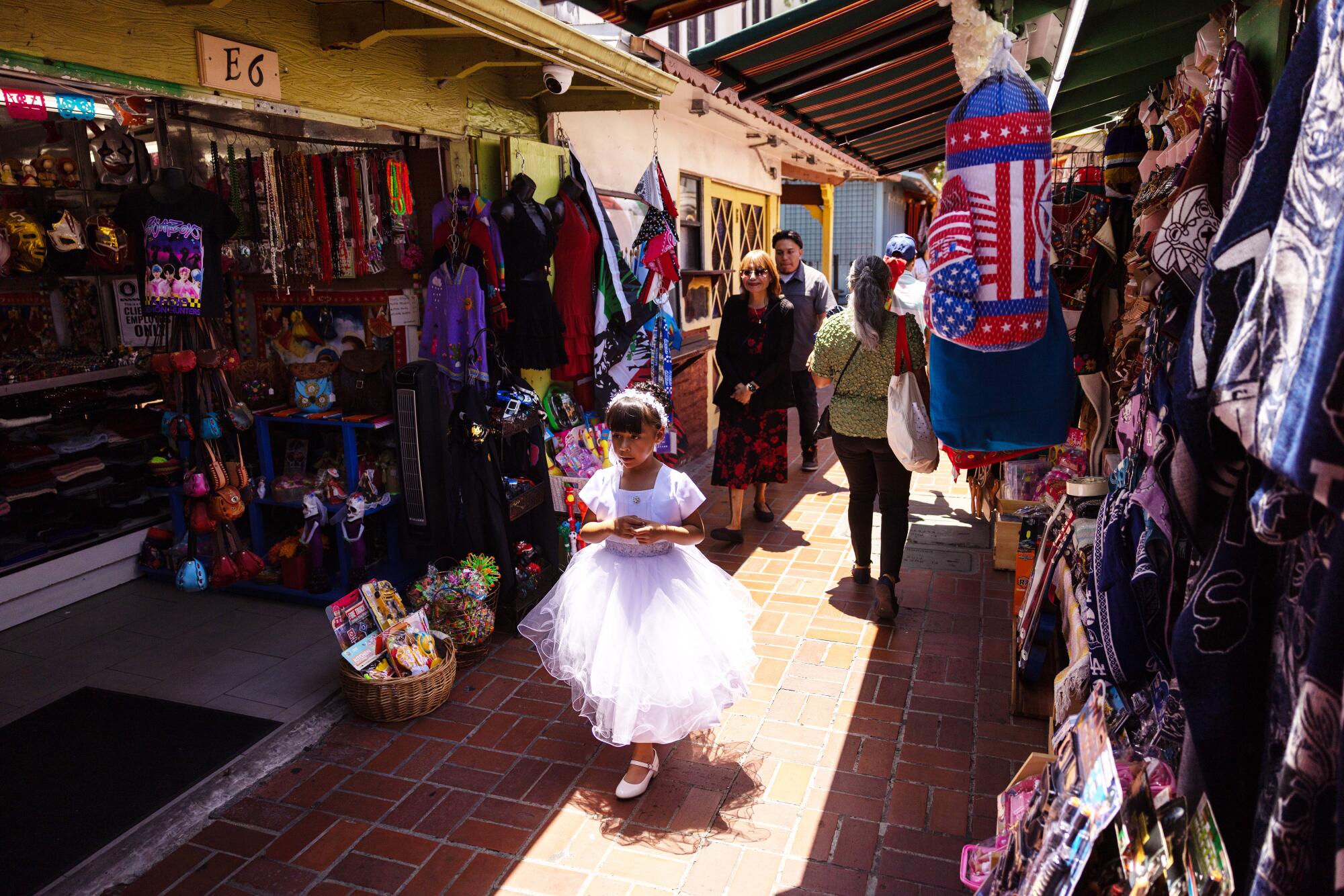Visitors walk among the stands and businesses of Olvera Street.