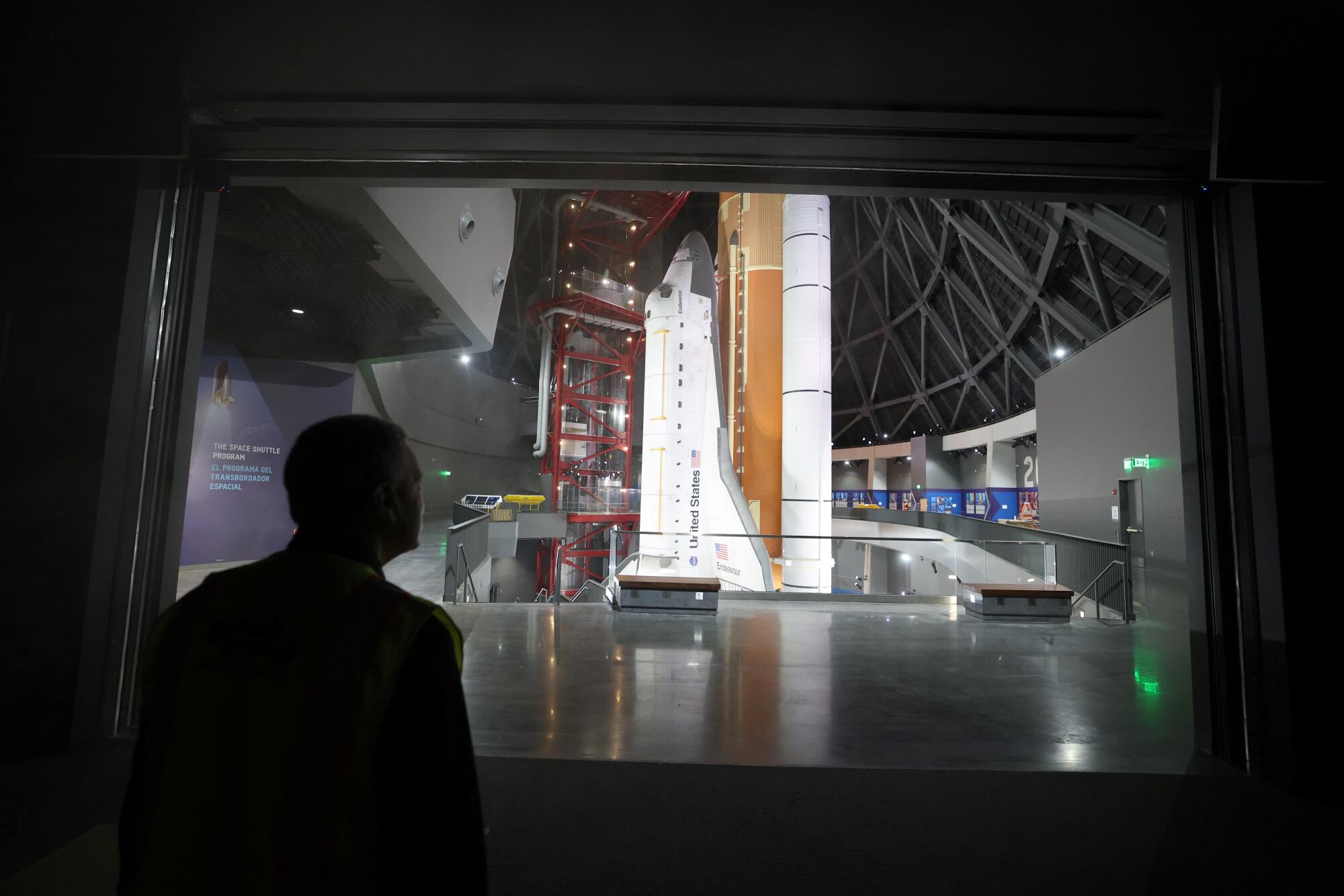 A man views the Endeavor shuttle from a viewing window.