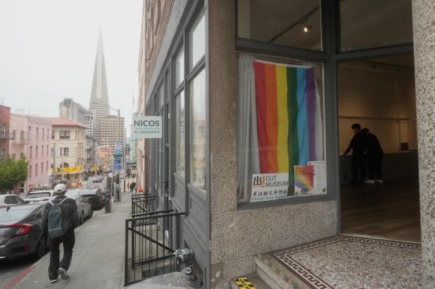 A pedestrian walks down the street next to OUT Museum in Chinatown, Monday, June 22, 2026, in San Francisco. (AP Photo/Jeff Chiu)