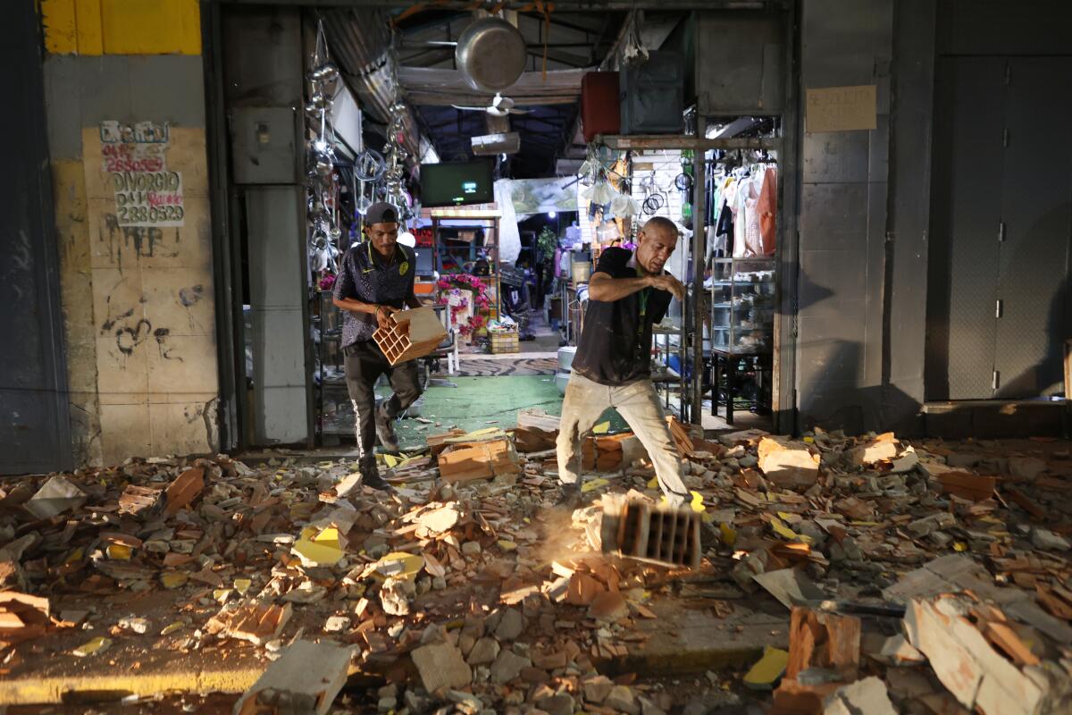 People walk in rubble.