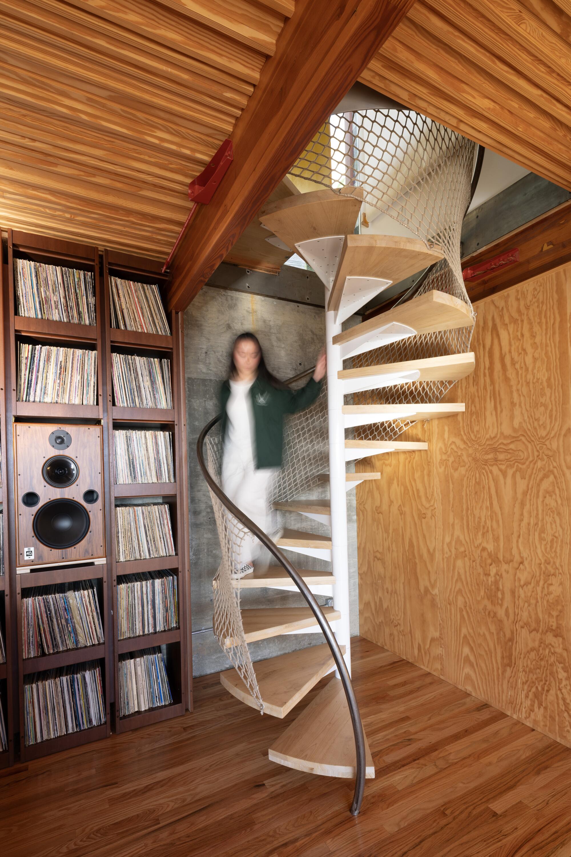 Hanna Li descends the spiral staircase to the music room