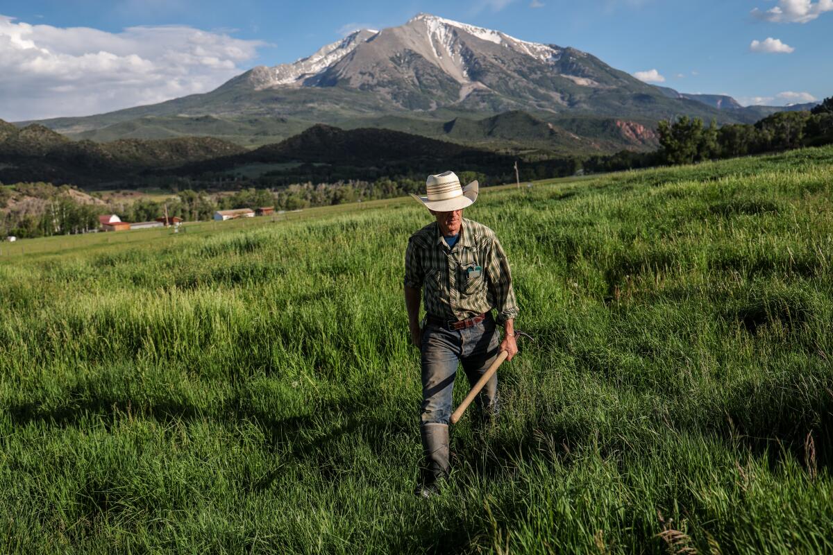 A rancher checks irrigation lines on one of his family's pastures near Carbondale, Colorado