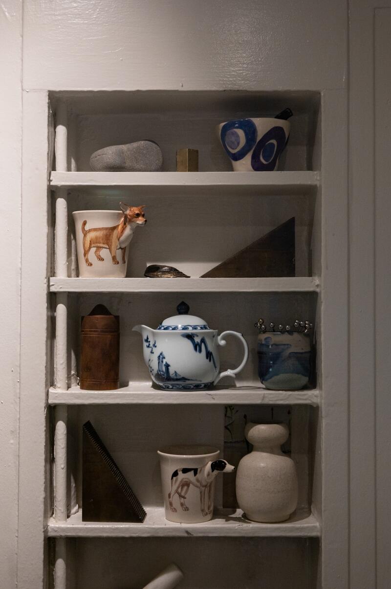Ceramics fill inset shelves in the kitchen.
