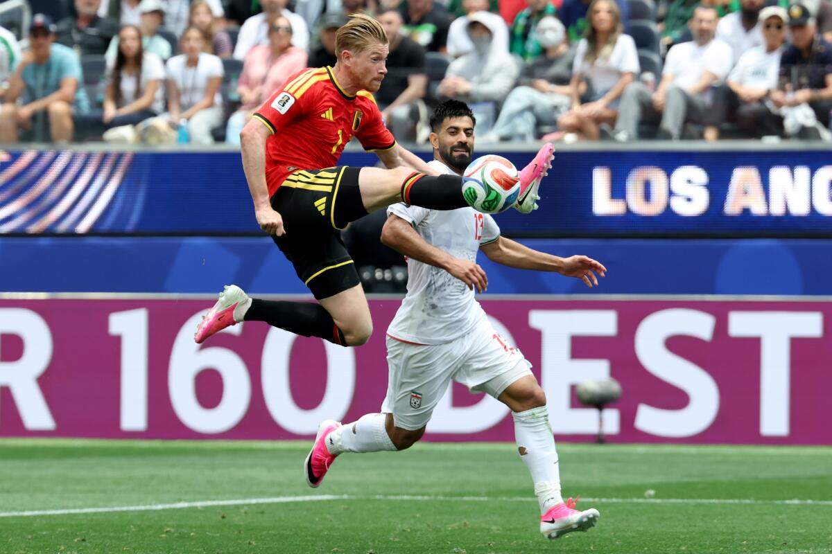 Belgium midfielder Kevin de Bruyne, left, kicks the ball against Iran defender Hossein Kanaanizadegan.