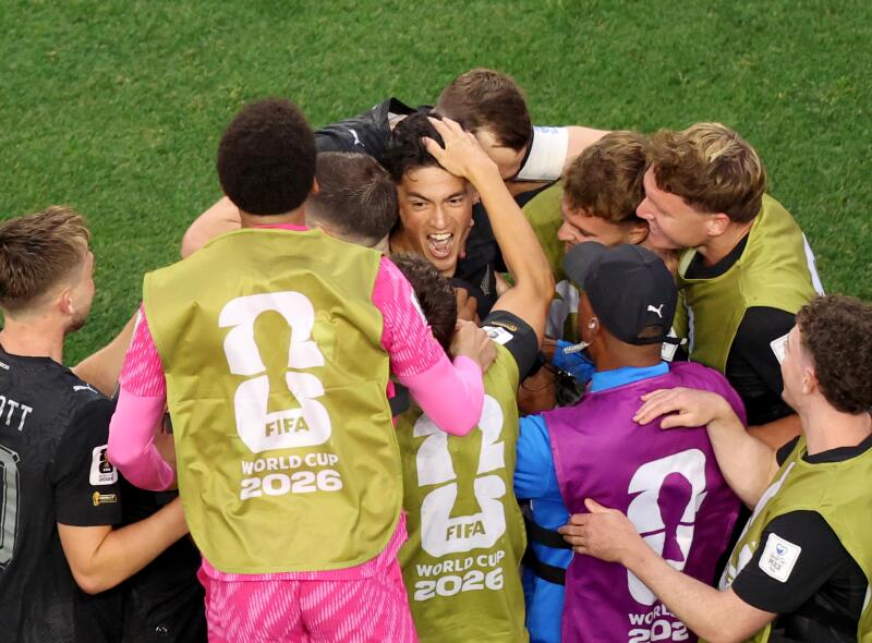 New Zealand forward Elijah Just, back center, celebrates with teammates after his second goal.