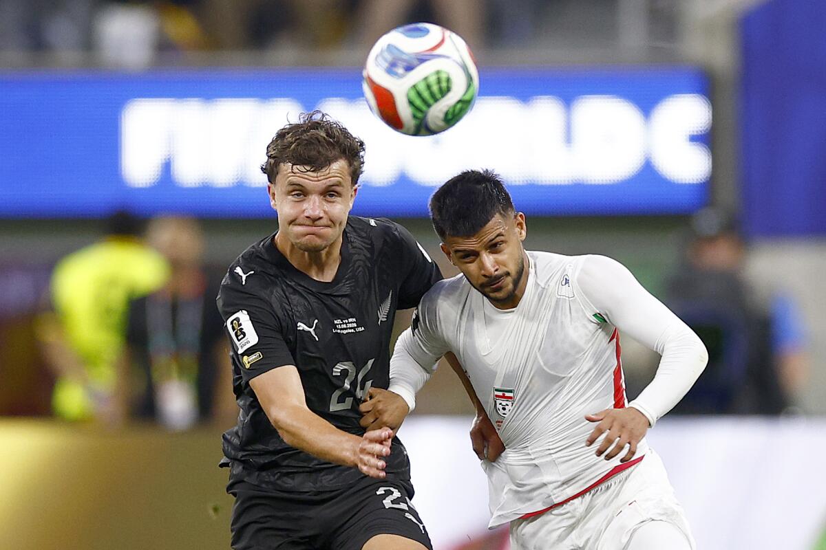 New Zealand defender Callan Elliot, left, and Iran midfielder Mehdi Ghayedi go after the ball.