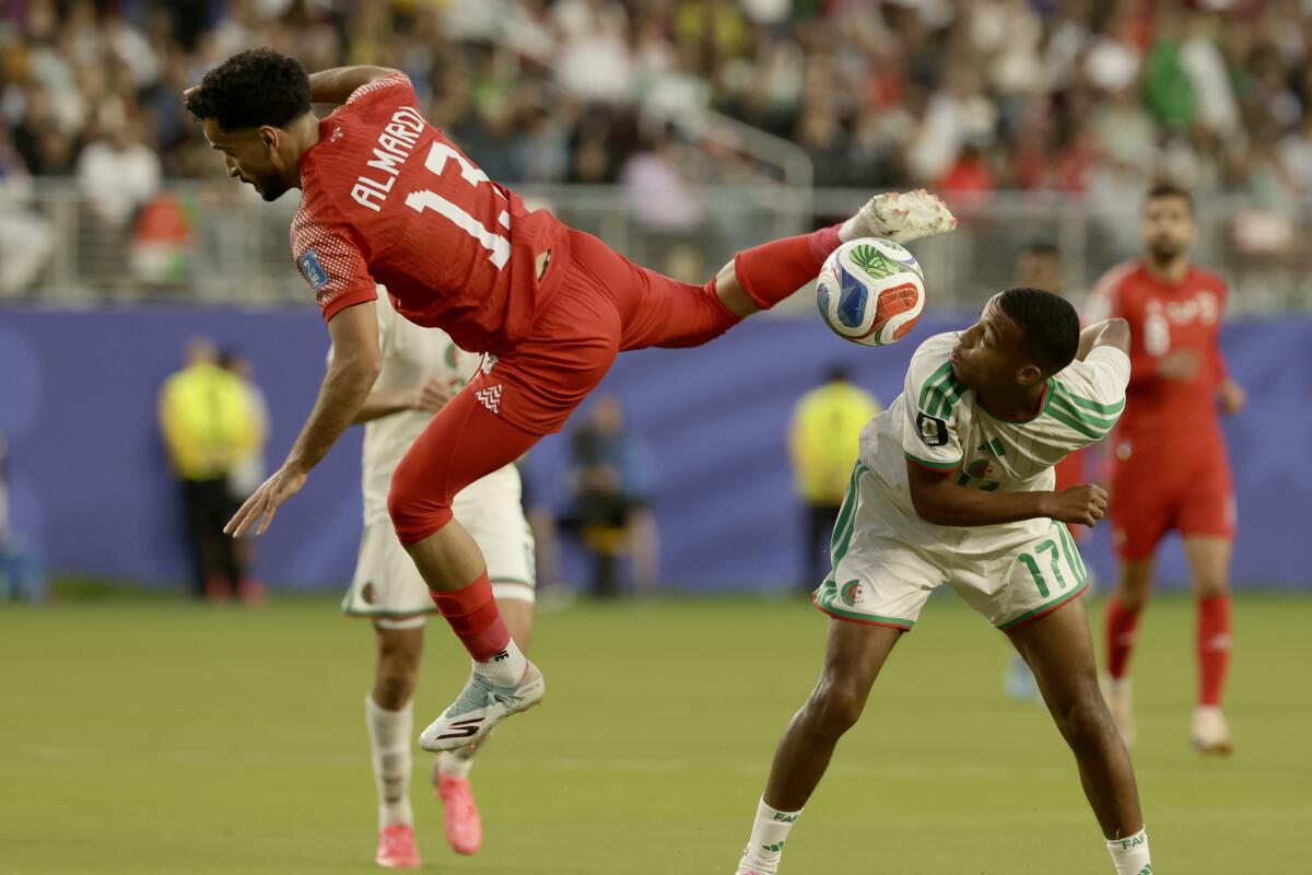 Jordan forward Mahmoud al-Mardi, left, and Algeria defender Rafik Belghali in action.
