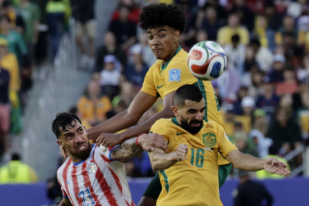 Paraguay forward Gabriel Avalos (21), left, and Australia defender Aziz Behich (16) in action 