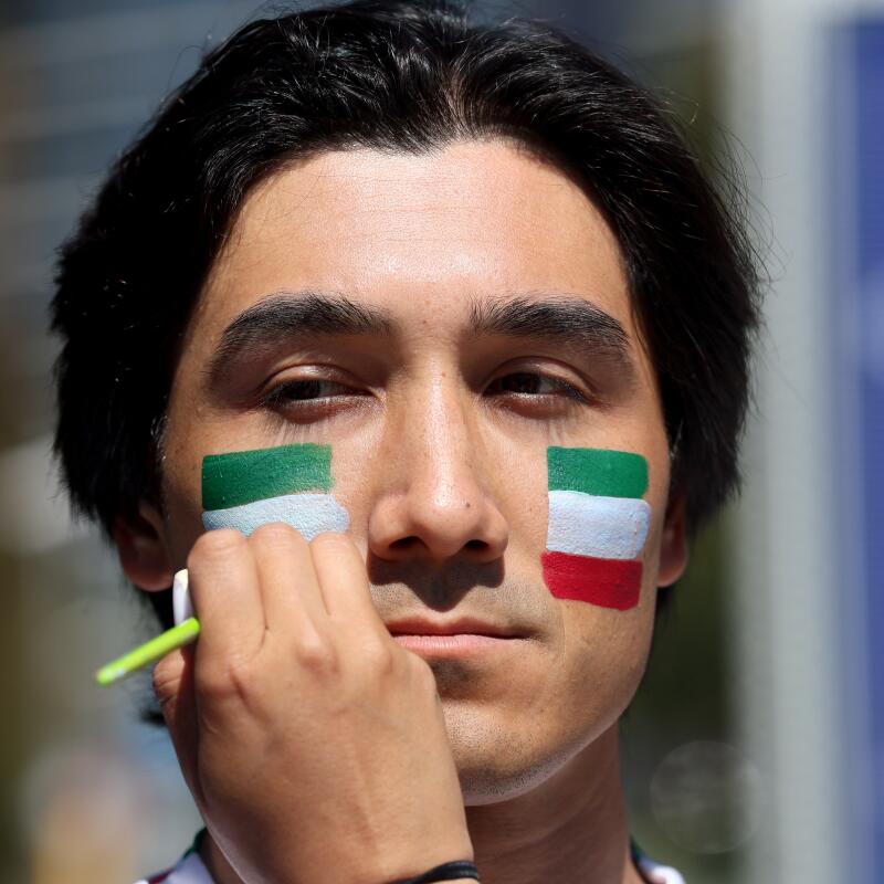 Kian Souresrafil, a Orange County resident, gets his face painted with an Iranian flag