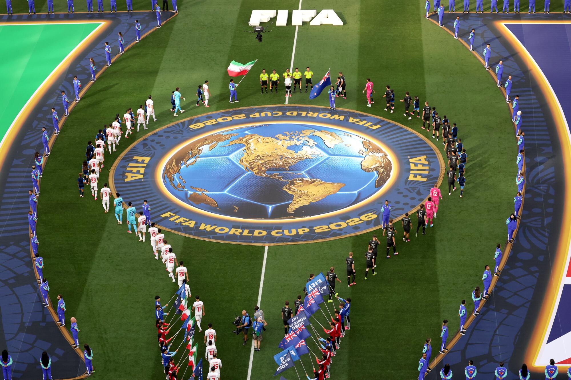 Team Iran and Team New Zealand enter the pitch before the World Cup group stage match.